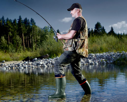 Pánské holínky Demar - muž v dešti s robustními pracovními gumáky